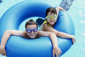 High angle view of a boy and a girl in an inflatable ring in a swimming pool